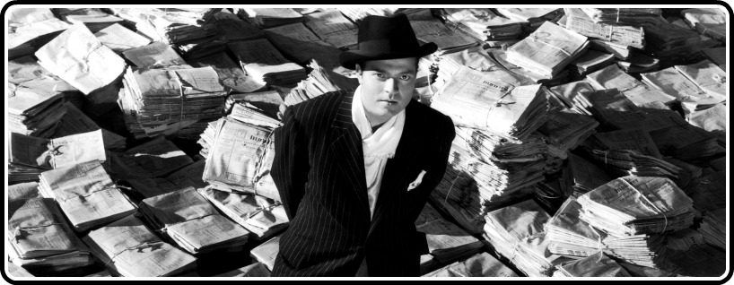 CITIZEN KANE, Orson Welles, 1941, astride stacks of newspaper